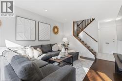 Living room featuring wood finished floors, stairway, and recessed lighting - 