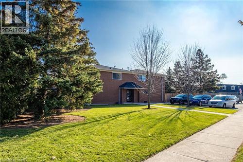View of side of property with a lawn and brick siding - 2069 Meadowbrook Road Unit# 4, Burlington, ON - Outdoor