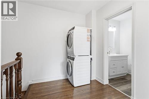 Washroom with dark wood-style flooring and stacked washer / drying machine - 2069 Meadowbrook Road Unit# 4, Burlington, ON - Indoor Photo Showing Laundry Room