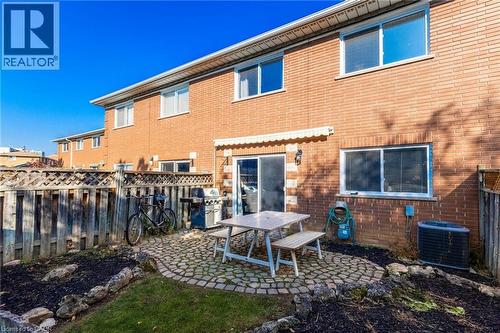 Back of property featuring brick siding, a fenced backyard, and a patio area - 2069 Meadowbrook Road Unit# 4, Burlington, ON - Outdoor With Exterior
