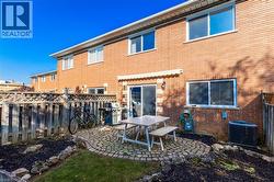 Back of property featuring brick siding, a fenced backyard, and a patio area - 