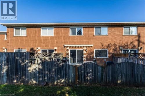 Back of house with a fenced backyard, brick siding, and a gate - 2069 Meadowbrook Road Unit# 4, Burlington, ON - Outdoor With Exterior