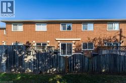 Back of house with a fenced backyard, brick siding, and a gate - 