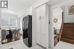 Kitchen with freestanding refrigerator, white cabinets, and light tile patterned floors - 