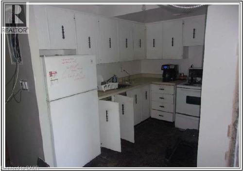 Kitchen with white appliances, white cabinetry, and light countertops - 150 Charlton Avenue E Unit# 708, Hamilton, ON - Indoor Photo Showing Kitchen