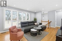 Living area with light wood-type flooring and recessed lighting - 