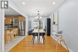 Dining area featuring light wood finished floors, a chandelier, and recessed lighting - 