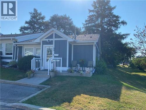 Bungalow-style house featuring a front yard and board and batten siding - 49 Bishop Reding Trail, Hamilton, ON - Outdoor