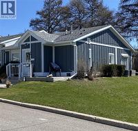 View of side of property featuring board and batten siding, roof with shingles, and a yard - 