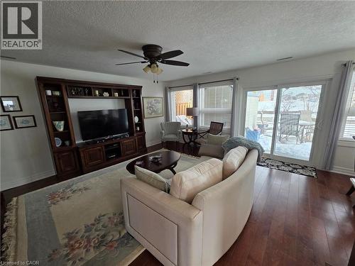 Living room with a textured ceiling, dark wood-type flooring, and ceiling fan - 49 Bishop Reding Trail, Hamilton, ON - Indoor Photo Showing Living Room
