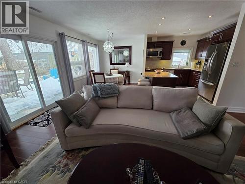 Living room with a textured ceiling, dark wood-style floors, a chandelier, and recessed lighting - 49 Bishop Reding Trail, Hamilton, ON - Indoor Photo Showing Living Room