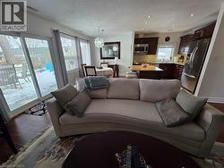 Living room with a textured ceiling, dark wood-style floors, a chandelier, and recessed lighting - 
