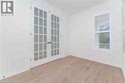 Empty room featuring light wood finished floors and french doors - 