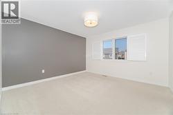 Empty room featuring light colored carpet and baseboards - 