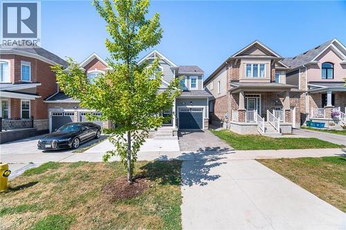 Craftsman-style home with concrete driveway, a porch, a front yard, and brick siding - 28 Pickett Place, Cambridge, ON - Outdoor With Facade