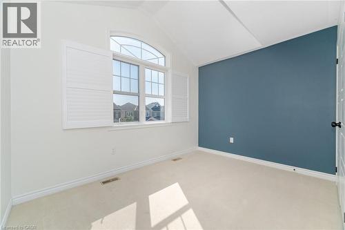 Carpeted spare room featuring lofted ceiling and baseboards - 28 Pickett Place, Cambridge, ON - Indoor Photo Showing Other Room