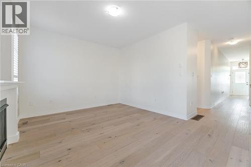 Unfurnished living room featuring light wood-style flooring and a fireplace - 28 Pickett Place, Cambridge, ON - Indoor Photo Showing Other Room With Fireplace