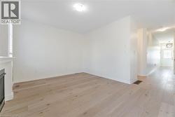 Unfurnished living room featuring light wood-style flooring and a fireplace - 