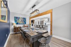 Dining space with a chandelier, light wood-type flooring, beamed ceiling, and a textured ceiling - 