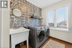 Laundry room with dark tile patterned flooring and washer and dryer - 