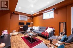 Living room with an office area, wood finished floors, recessed lighting, and ornamental molding - 