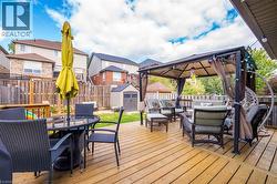 Deck with outdoor lounge area, a gazebo, outdoor dining area, a storage shed, and a fenced backyard - 