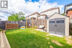 Fenced backyard featuring a storage shed, a residential view, and a patio area - 
