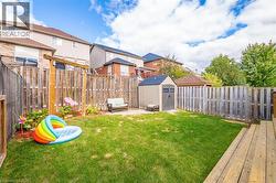 Fenced backyard featuring a storage shed, a residential view, and a patio - 