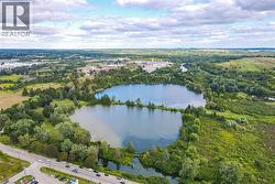 Drone / aerial view of a nearby body of water and a heavily wooded area - 