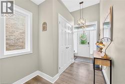 Entryway with light wood-style floors and a chandelier - 