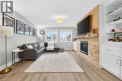 Living room featuring a tiled fireplace and light wood-type flooring - 