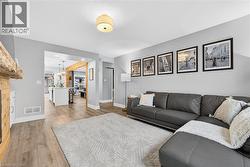 Living room featuring light wood-style floors and a chandelier - 