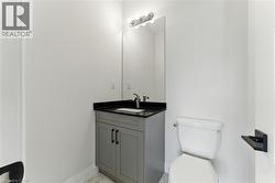 Half bath with vanity and light marble finish flooring - 