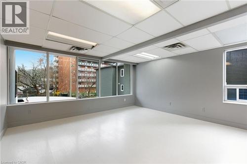 Unfurnished room featuring a drop ceiling and wood finished floors - 17 King Street E Unit# 205, Dundas, ON 