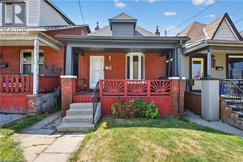 View of front of property featuring brick siding, covered porch, and a front lawn - 111 Hillyard Street, Hamilton, ON - Outdoor