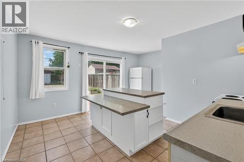 Kitchen with white cabinetry, freestanding refrigerator, a center island, and light tile patterned floors - 111 Hillyard Street, Hamilton, ON - Indoor