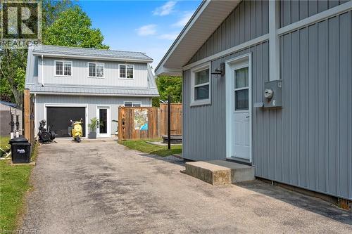 View of front facade featuring a garage, board and batten siding, and asphalt driveway - 197 Cedar Drive, Turkey Point, ON - Outdoor
