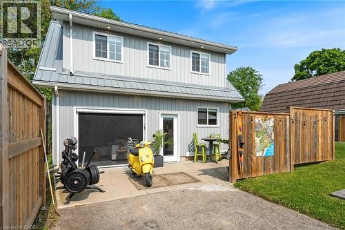 Rear view of house featuring a patio, board and batten siding, and a metal roof - 197 Cedar Drive, Turkey Point, ON - Outdoor With Exterior