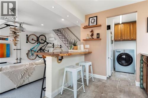 Kitchen featuring a breakfast bar area, washer / dryer, a peninsula, open shelves, and freestanding refrigerator - 197 Cedar Drive, Turkey Point, ON - Indoor Photo Showing Laundry Room