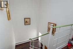 Staircase with wood finished floors and baseboard heating - 