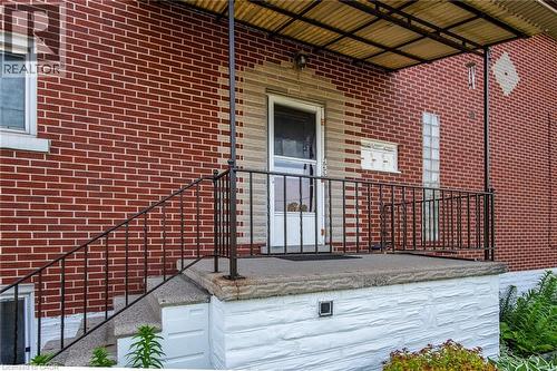 Doorway to property featuring brick siding and a porch - 129 River Road E, Kitchener, ON - Outdoor With Exterior