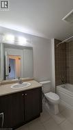 Full bath with vanity, bathtub / shower combination, and light tile patterned floors - 