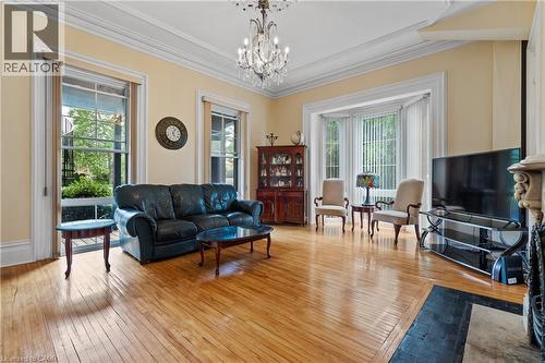 Living area featuring a chandelier, ornamental molding, and light wood-style flooring - 5368 Menzie Street, Niagara Falls, ON - Indoor Photo Showing Living Room