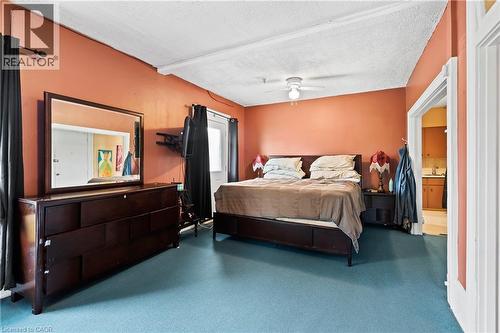 Bedroom featuring a textured ceiling, carpet flooring, a ceiling fan, and connected bathroom - 5368 Menzie Street, Niagara Falls, ON - Indoor Photo Showing Bedroom