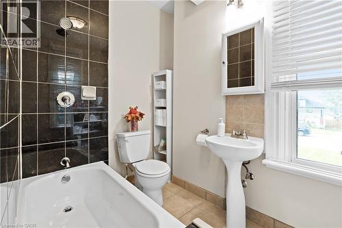 Full bath featuring tile patterned floors, decorative backsplash, and shower / washtub combination - 5368 Menzie Street, Niagara Falls, ON - Indoor Photo Showing Bathroom