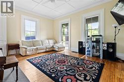 Living area featuring healthy amount of natural light, hardwood / wood-style floors, ceiling fan, and ornamental molding - 