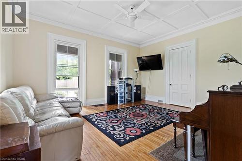 Living area featuring a ceiling fan, coffered ceiling, wood finished floors, and crown molding - 5368 Menzie Street, Niagara Falls, ON - Indoor Photo Showing Other Room