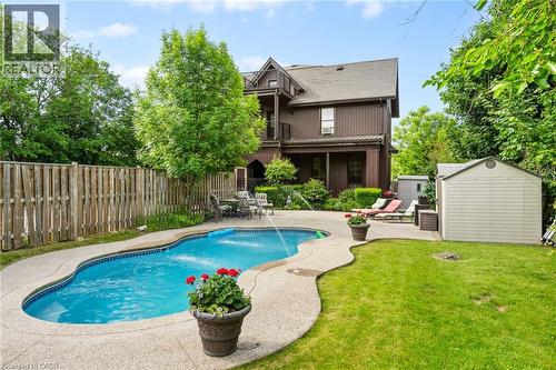 Rear view of house featuring a balcony, a shed, a patio area, and a fenced backyard - 5368 Menzie Street, Niagara Falls, ON - Outdoor With In Ground Pool