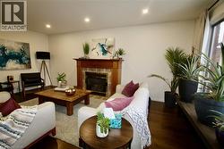 Living room with wood finished floors, a fireplace, and recessed lighting - 