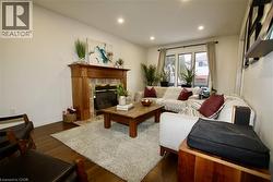 Living room with dark wood finished floors, a fireplace, and recessed lighting - 